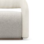 A stylish Emma Armchair with tubular armrests and backrest, featuring a fluffy seat, all upholstered in boucle. The chair combines modern design with cozy comfort.