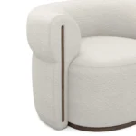 Camille armchair detail by Nolita Harbour, sculptural bouclé chair with rounded back, deep seat, and elegant walnut accents.