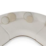 Camille modular sofa detail by Nolita Harbour in bouclé, curved sectional with continuous back and architectural walnut plinth.