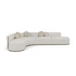 Camille luxury sofa by Nolita Harbour, curved bouclé sectional with sculptural form, precise seams, and grounded wood plinth.