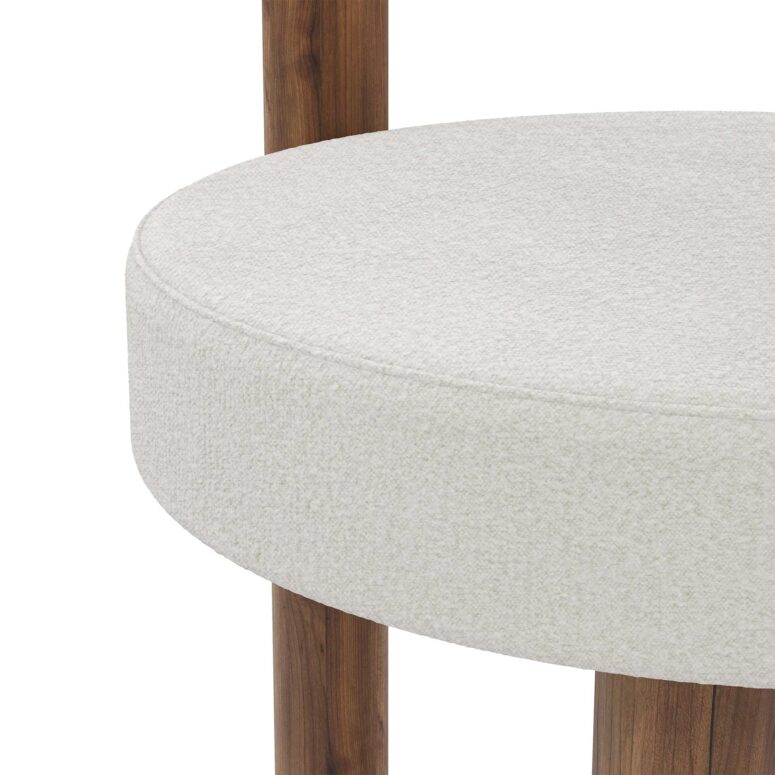 A stylish Odette Dining Chair upholstered in boucle fabric, featuring a matte walnut base. The chair combines modern design with cozy comfort.