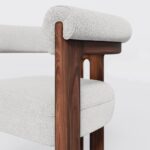 Mathilde dining chair with a unique three-leg walnut base and plush bouclé fabric upholstery, offering both comfort and modern elegance for dining spaces.