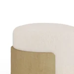 Detail view of Gilda ottoman stool by Nolita Harbour in fabric and oak, sculptural accent piece with circular padded seat and elegant wood detailing.