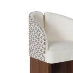 Melli bouclé dining chair details by Nolita Harbour, luxury upholstered chair with curved shell, walnut base, and refined brass detail.