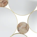 Details of Monique Mirror by Nolita Harbour, luxury wall mirror crafted in brass and Aegean Rose marble, showcasing layered circular mirrors with precise metal detailing, forming a sculptural statement piece that enhances light, material contrast, and spatial depth in sophisticated living spaces.