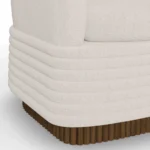 Close-up of Nina upholstered sofa by Nolita Harbour in bouclé, linear sofa with recessed walnut frame and soft sculptural form.