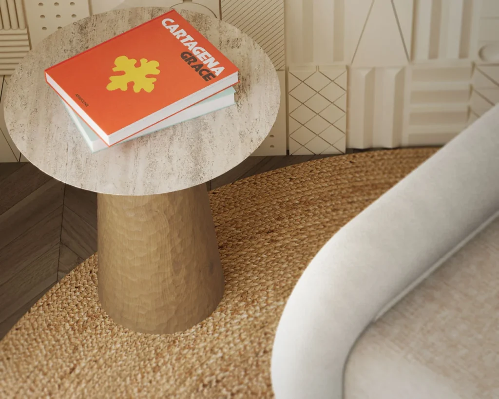 A chic Elke Side Table with a travertine top and a carved oak base with varnish finish. The table combines natural elegance with intricate craftsmanship.