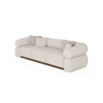 Soléne sectional sofa by Nolita Harbour, bouclé upholstered sofa with walnut base and cylindrical arms, sculptural curved design.