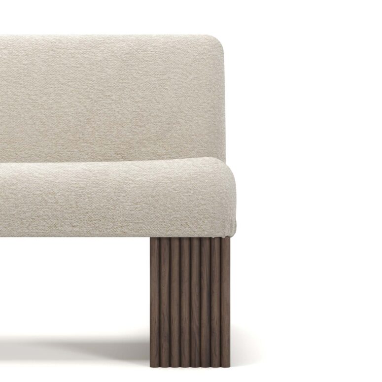 Modern armchair with cream upholstery, featuring ribbed walnut base and plush seating, designed by Nolita Harbour. detail view