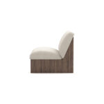 Modern armchair with cream upholstery, featuring ribbed walnut base and plush seating, designed by Nolita Harbour. Side view