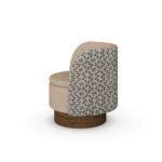 Beige luxury armchair with patterned fabric back and sides, and a walnut base, designed by Nolita Harbour.