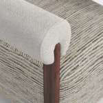 Claire luxury armchair detail by Nolita Harbour, upholstered lounge chair with visible walnut base and refined cylindrical arms.