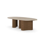 Santi dining table with travertine top, brass frieze, and ribbed walnut matte base. 45 degree view