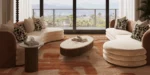 Latte sofa by Nolita Harbour, curved velvet and bouclé sectional sofa with walnut base, sculptural seating in a light-filled modern living room.