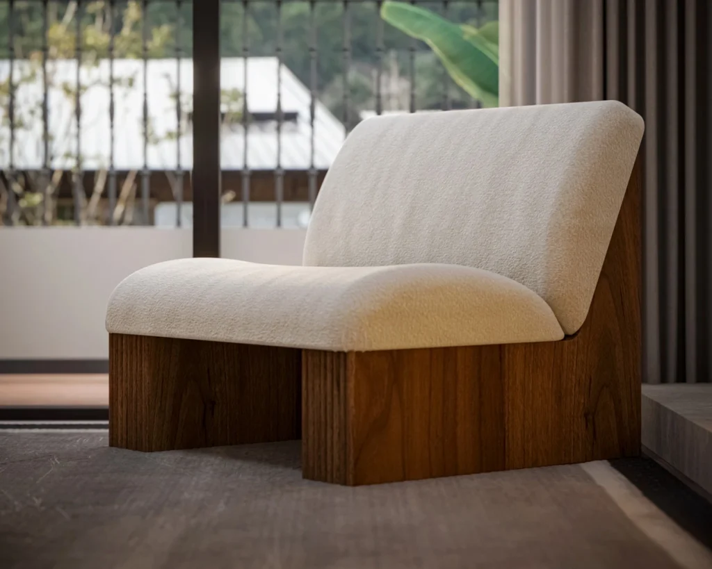 Modern armchair with cream upholstery, featuring ribbed walnut base and plush seating, designed by Nolita Harbour. detail view