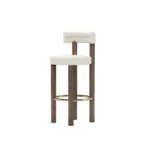Odette bar chair by Nolita Harbour, bouclé bar stool with walnut legs and brass footrest, sculptural curved-back design.