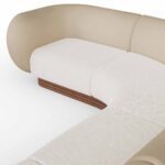 Curved sectional sofa with taupe leather upholstery, cream fabric seat cushions, and a walnut base, designed by Nolita Harbour. detail view