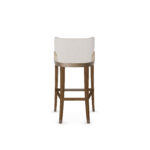 Elegant bar chair with a curved upholstered backrest, beige cushioned seat, and walnut wood legs with metal accents, designed by Nolita Harbour for modern bar settings. Back view