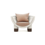 Modern armchair with a curved frame, upholstered in soft fabric, featuring ribbed walnut legs, and plush beige cushions, by Nolita Harbour. Anna Armchair 45 front view