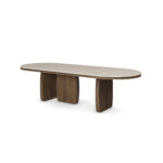 Assia Oval dining table with a smooth travertine tabletop and sculptural walnut legs, crafted by Nolita Harbour.