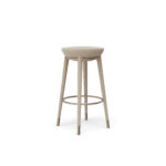 Minimalist backless bar stool with a curved seat, sleek frame, and a circular footrest, designed by Nolita Harbour.