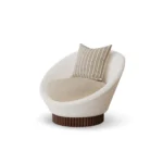 Anki armchair by Nolita Harbour, velvet upholstered armchair with ribbed walnut base and sculptural curved silhouette.