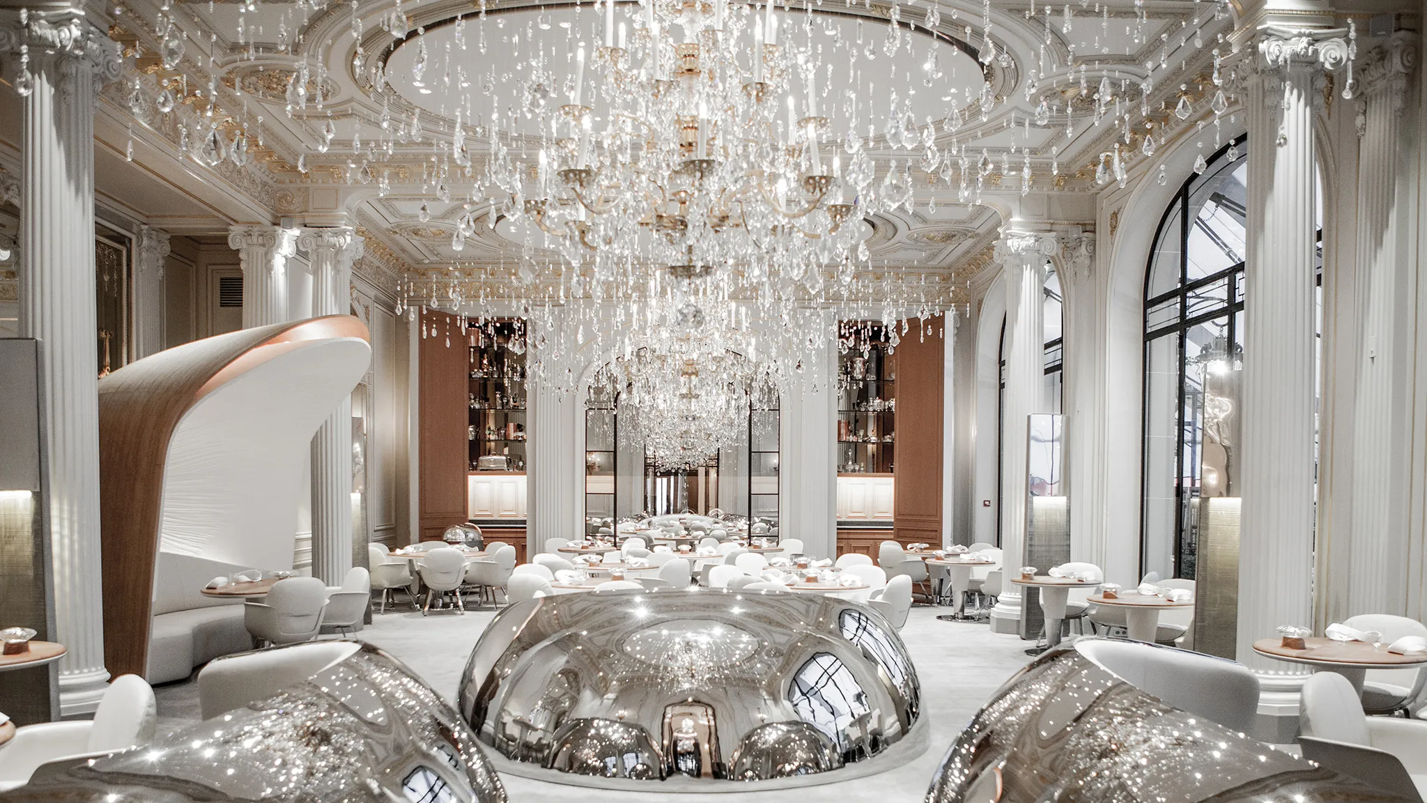 "Elegant fine dining restaurant at Hôtel Plaza Athénée in Paris, featuring luxurious décor with chandeliers, plush seating, and a sophisticated ambiance." - Nolita Harbour 