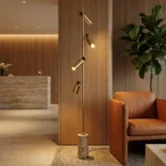 A Hotel lobby, with an area with the Alan floor lamp, by Nolita Harbour, iluminating a sofa and corner with its soft, directional glow.