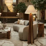 An interior with Nolita Harbour furniture, suchas a modern, minimalistic couch and a sculptural wooden lamp illuminating the room.