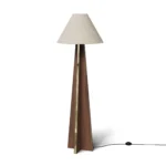 Bapt Floor Lamp, a sculptural floor lamp by Nolita Harbour in wood, brass, and fabric, with a geometric carved base and soft glow.
