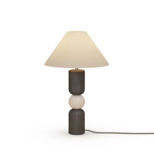 Luuk Table Lamp, a sculptural table lamp by Nolita Harbour in black wood, travertine, and fabric shade, casting a warm glow.