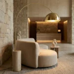 Hotel lobby with a sofa and Nils floor lamp, by Nolita Harbour, set against a stone all, showcasing a luxurious and warm hospitality.