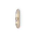 Taj Wall Lamp, a sculptural wall lamp by Nolita Harbour that combines travertine, a brass frame, and fluted glass diffuser.