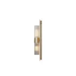 Taj Wall Lamp, a refined wall lamp by Nolita Harbour in travertine and brass with fluted glass, offering a warm light.