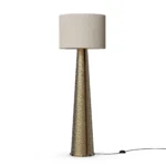 Yves Floor Lamp, a sculptural floor lamp by Nolita Harbour in hammered brass with fabric shade, casting a warm ambient glow.