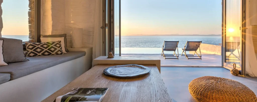 Villa Piedra Mykonos with sea view terrace, infinity pool, and cozy Mediterranean-inspired interiors at sunset.