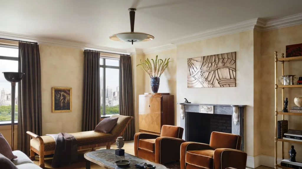 Classic Art Deco interior in a New York apartment featuring sculptural armchairs, warm tones, geometric wall art, and refined period detailing.