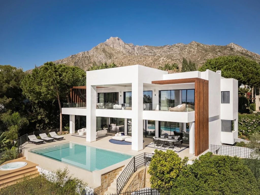 Architect-designed Marbella villa with symmetrical courtyard, lush tropical landscaping, and refined outdoor living spaces that elevate luxury residential property value.