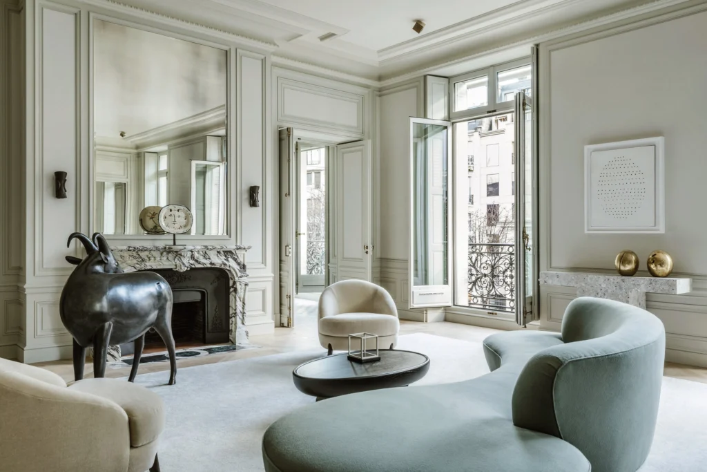 Refined Parisian luxury interior with sculptural furniture, curated artworks, and a view toward the Eiffel Tower, combining heritage architecture with minimalist design.