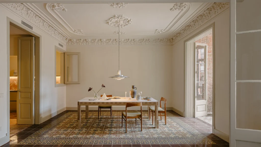 Barcelona Eixample apartments featuring soaring ceilings, restored Catalan modernist interiors, hydraulic mosaic floors, ornate plaster moldings, and elegant contemporary furnishings in a light-filled historic residence.
