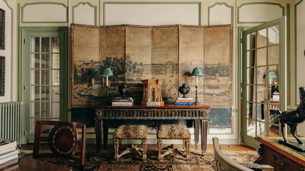 Antique console and folding screen set within a refined classical interior, illustrating eclectic interior design that blends historic craftsmanship with contemporary restraint