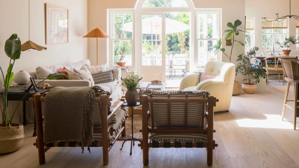 Neutral living rooms showcasing layered neutral interior design with textured linen and bouclé seating, warm wood furniture and paneling, sculptural coffee tables, soft area rugs, marble fireplaces, and refined metal lighting accents—demonstrating depth and dimension in contemporary neutral interiors.