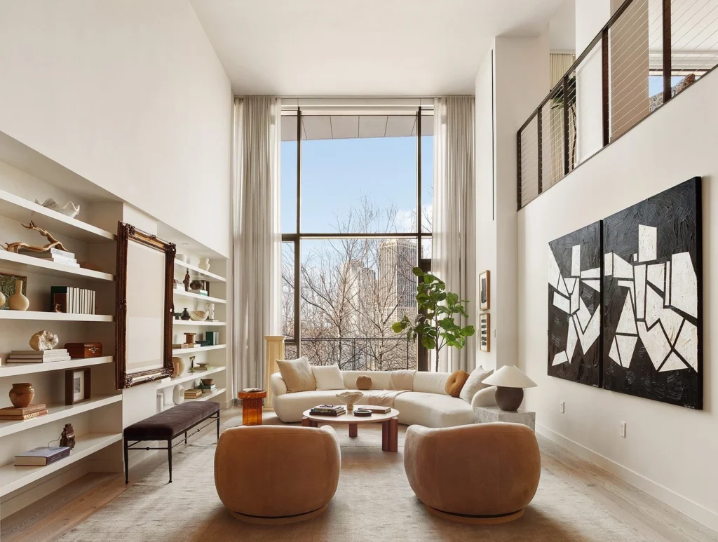 Modern luxury living rooms featuring sculptural swivel armchairs in leather and velvet, styled within contemporary open-plan interiors with double-height windows, curated artwork, and refined architectural details.
