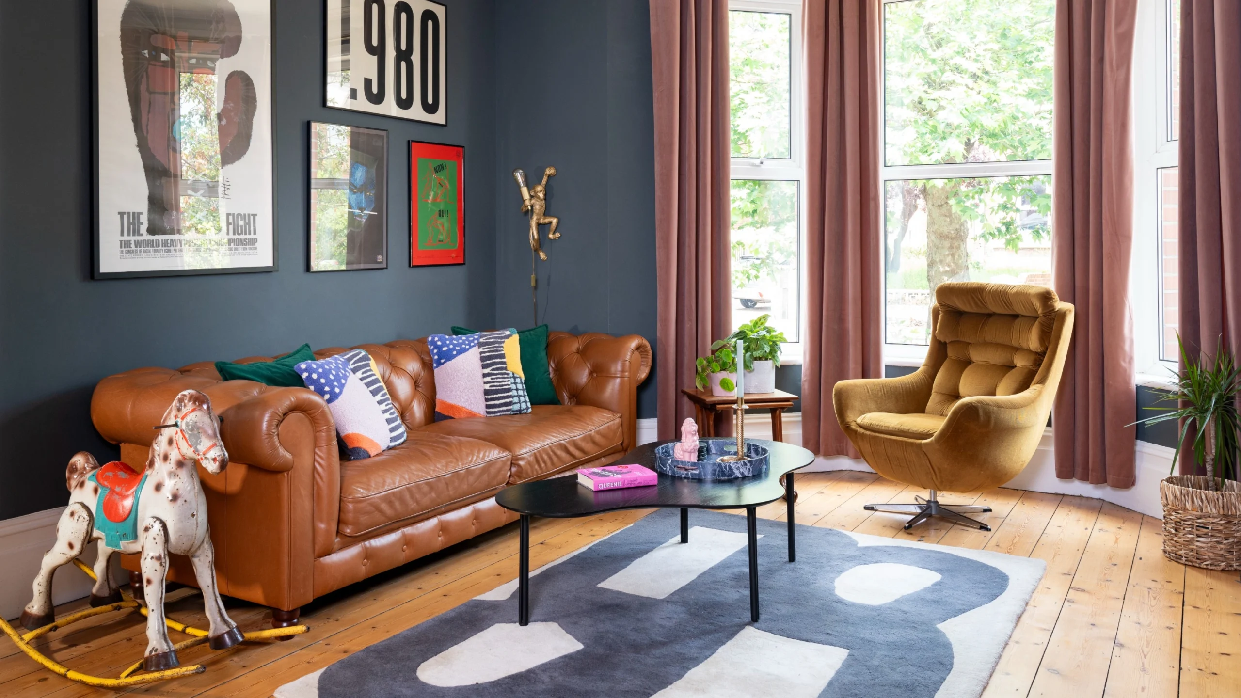 Modern luxury living rooms featuring sculptural swivel armchairs in leather and velvet, styled within contemporary open-plan interiors with double-height windows, curated artwork, and refined architectural details.