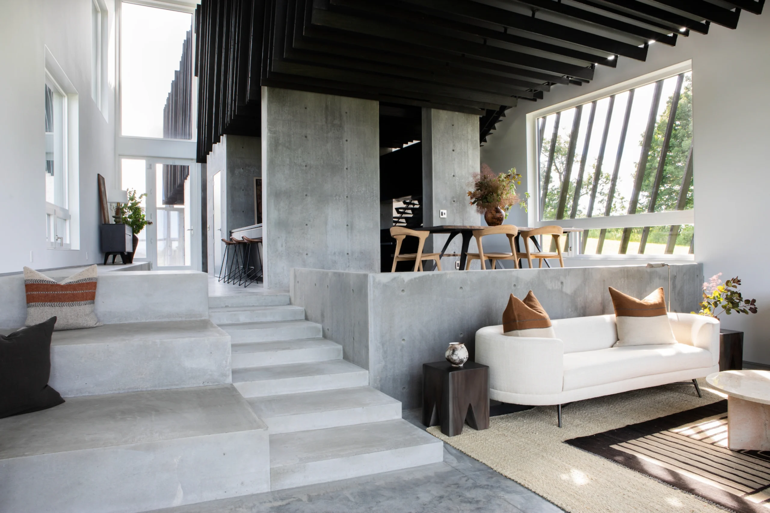 Contemporary open-plan living space where modular upholstered seating follows architectural lines, emphasizing balance between structural volumes and furniture placement principles.