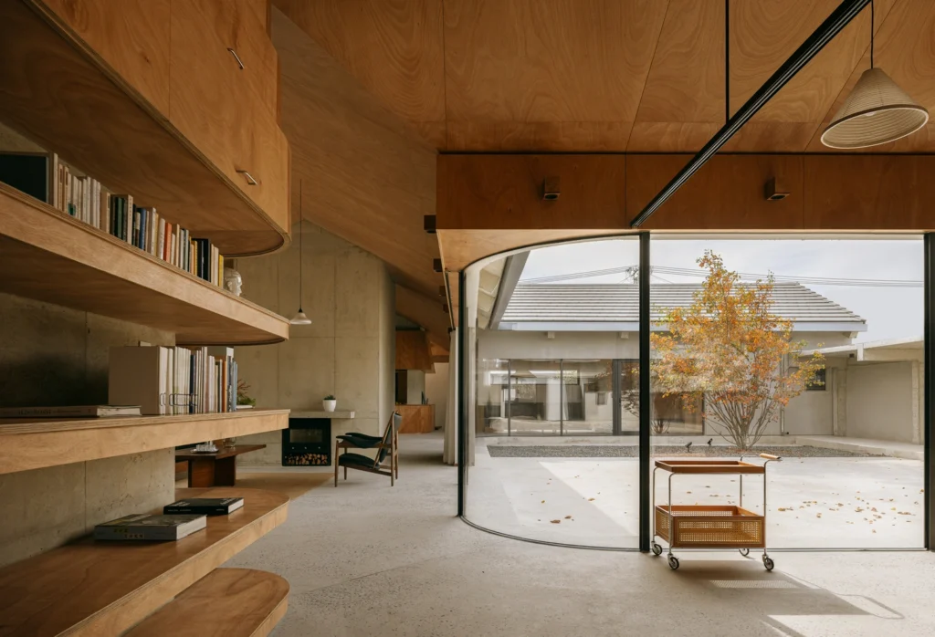 Minimalist interior with exposed concrete staircases and layered seating, illustrating how furniture placement responds to architectural structure and circulation flow.