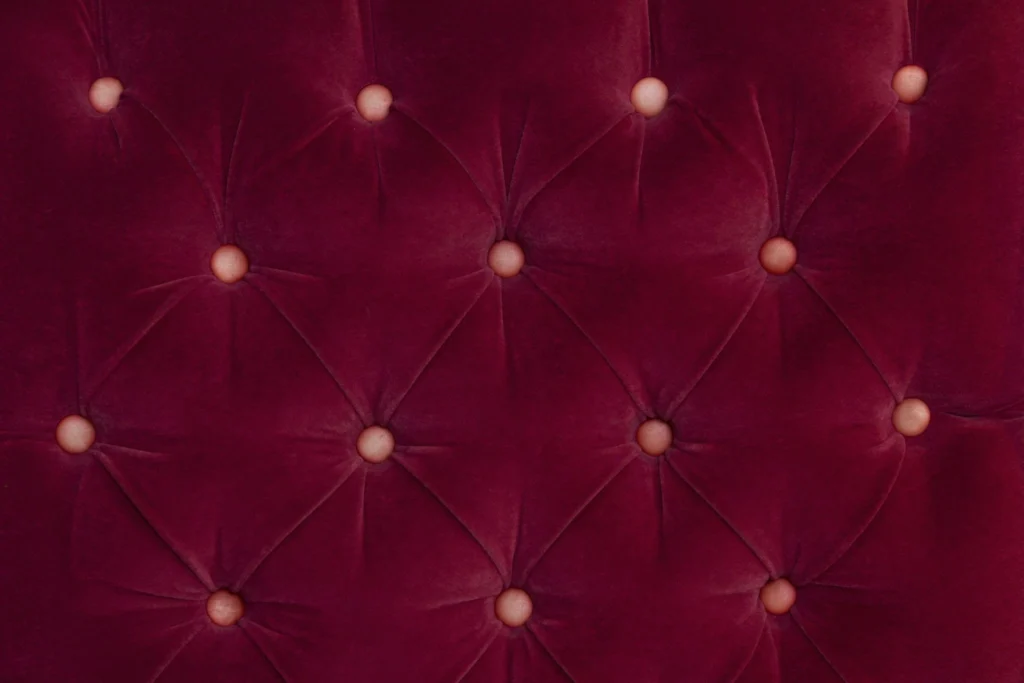 Tufted red velvet upholstery detail highlighting plush texture, craftsmanship, and the importance of luxury upholstery care for statement furniture pieces