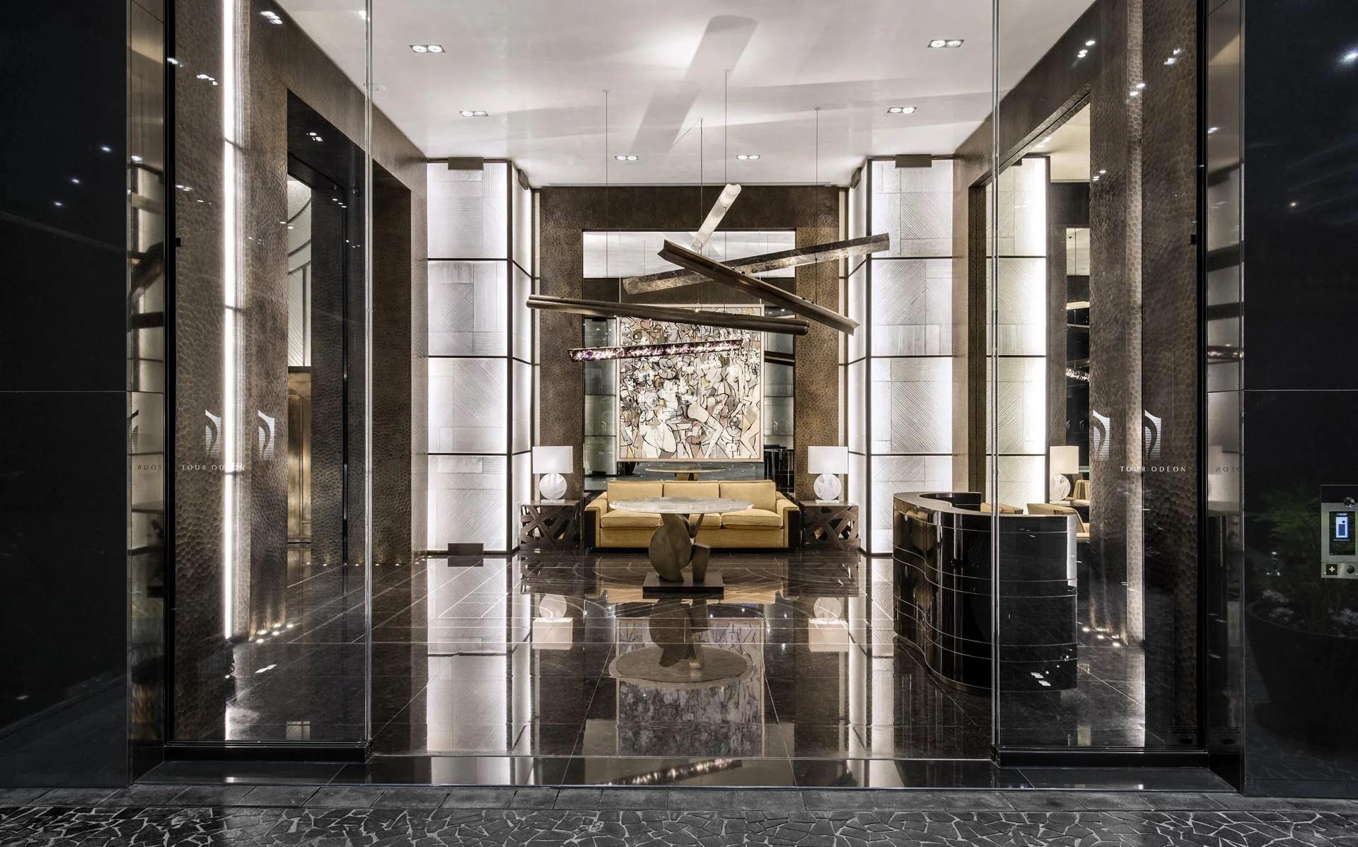 Luxurious modern interior with reflective black marble floors, geometric ceiling lights, a large abstract painting, and elegant beige furniture.