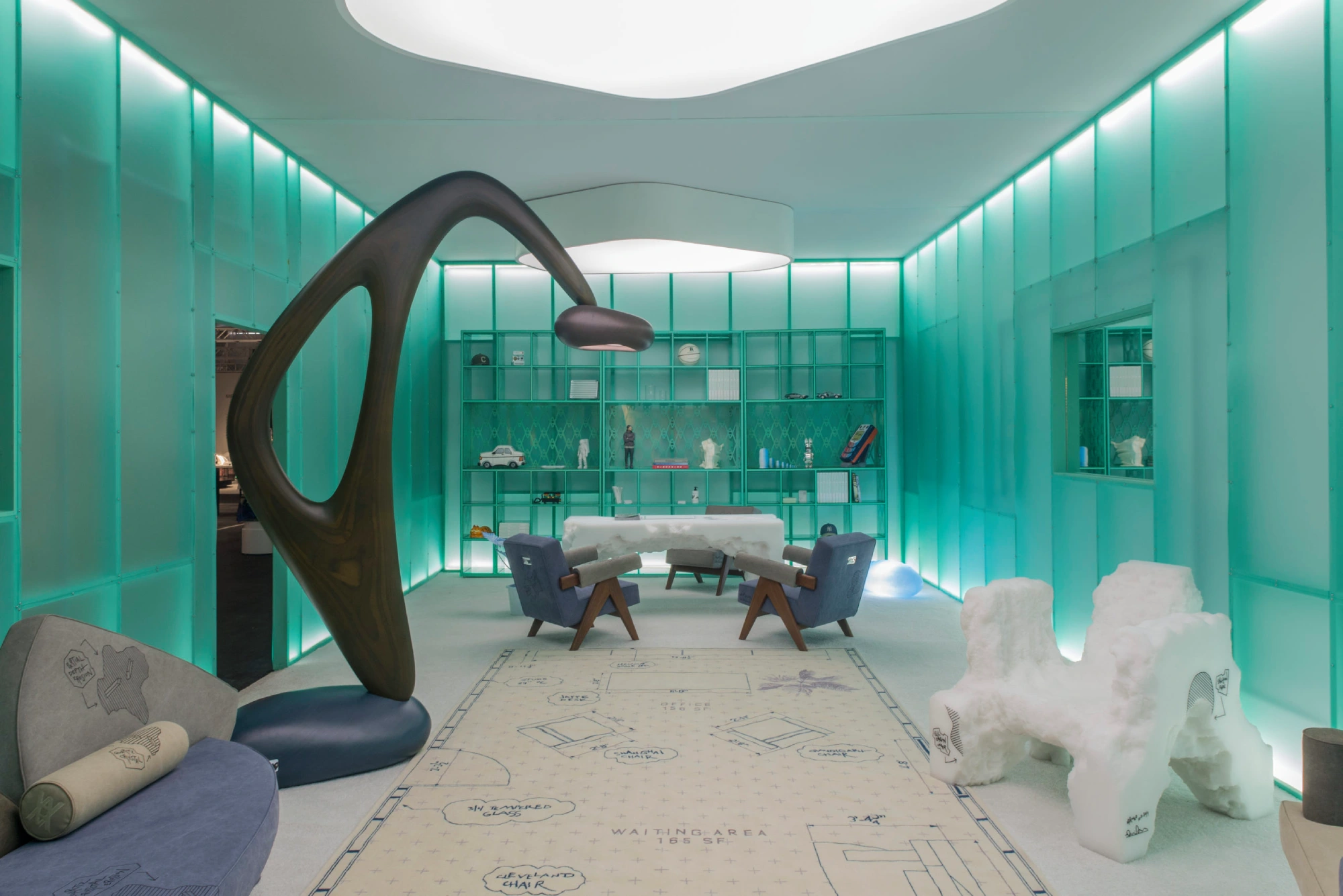 Futuristic room with turquoise lighting, abstract wood sculpture, modern furniture, and a large rug featuring blueprints, conveying an avant-garde feel.