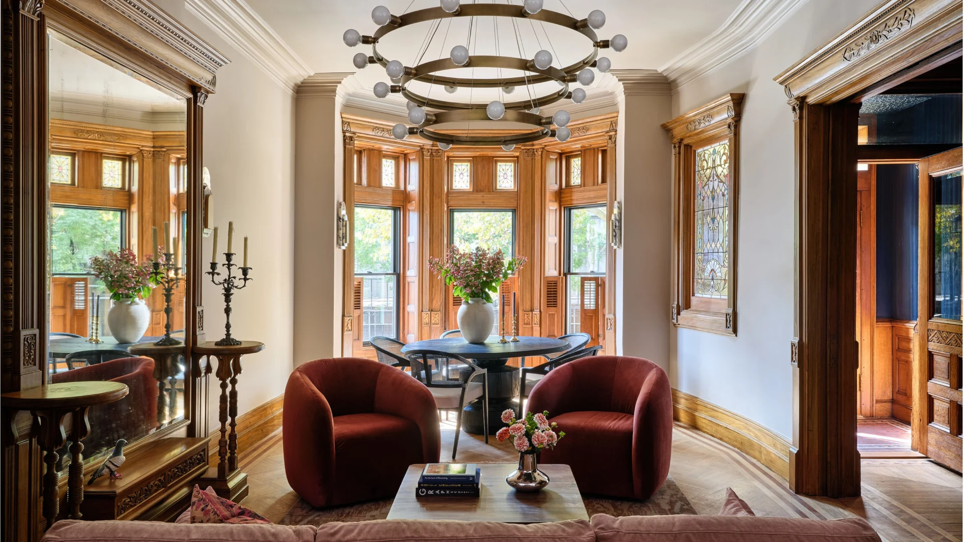 Chelsea townhouse interiors showcasing a refined parlor floor living room layout with floating seating, preserved historic windows, marble fireplaces, and thoughtful historic home furniture placement bathed in natural light